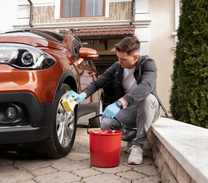 Lavage auto à domicile Pirey : professionnel intervenant sur un véhicule